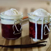 Two jars of Rote Grutze with vanilla sauce and ice cream