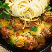 Skillet with Gluten Free Meatballs in tomato sauce, with cheese and spaghetti.