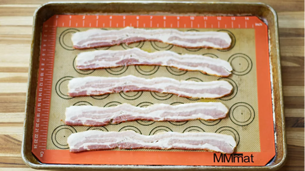 Raw bacon on a Silpat mat ready to be oven roasted.