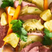 Platter of sliced Sous Vide Corned Beef, Slow Cooker Cabbage, boiled and roasted potatoes and carrots.