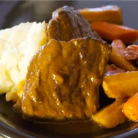 Up close shot of Braised Pot Roast served with carrots, parsnips and mashed potatoes.
