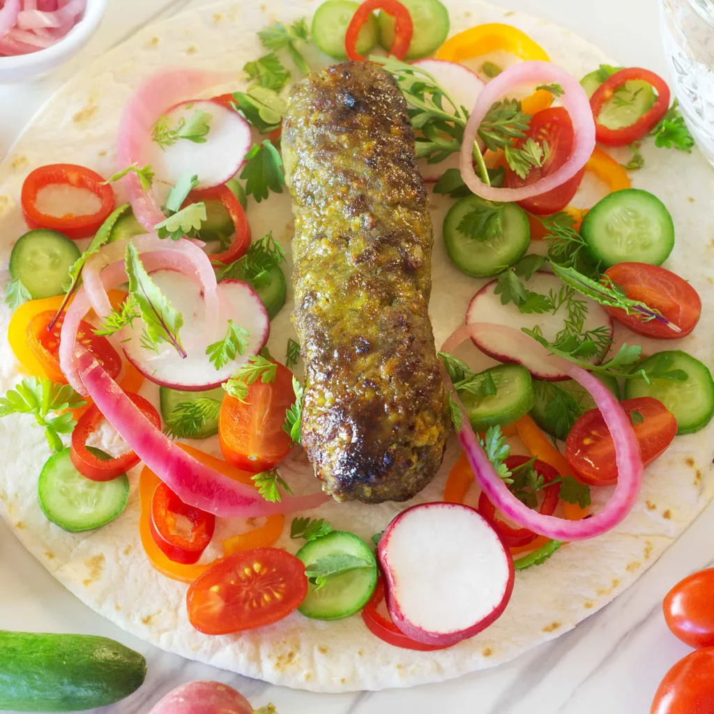 Lamb kofta wrap with assorted vegetables.