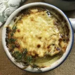 Bowl of French Onion Soup with thyme garnish.