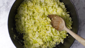Pot containing butter, onions, and cabbage mixed together in preparation for making Colcannon.
