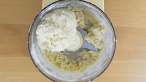 Shortbread dough in a food processor bowl.