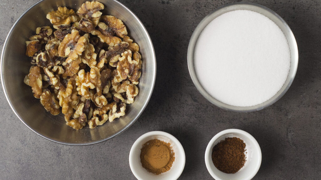 Ingredients needed to make spiced candied walnuts - walnuts, sugar, cinnamon and clove.